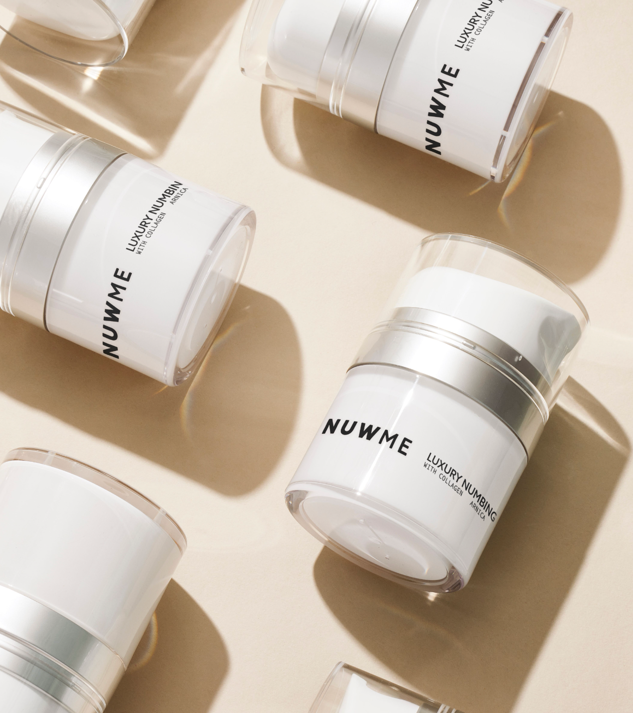 NUWME luxury numbing cream jars with CAAP Technology™ for advanced skincare prep.